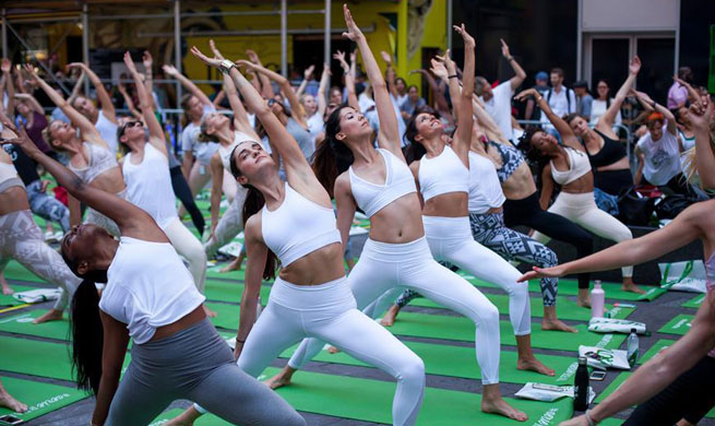 People participate in free yoga class to celebrate solstice in New York